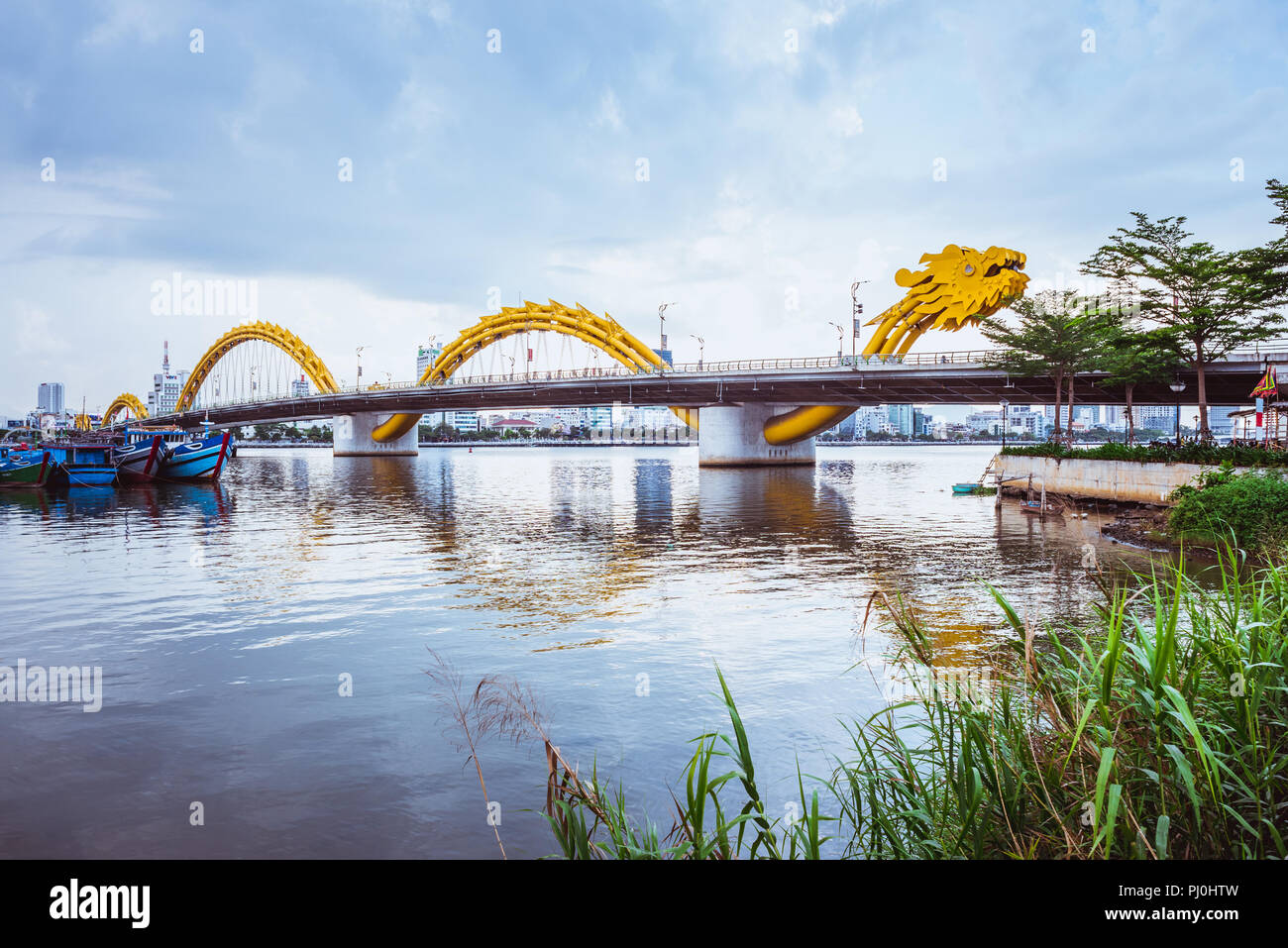 Da Nang, Vietnam - May 7, 2018: Dragon Bridge against the overcast sky, view from an embankment. Stock Photo