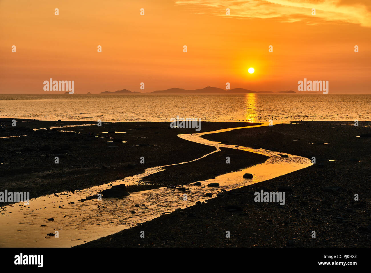 Sunset with mudflat and tidal channel at Ganghwado Janghwa-ri sunset viewing point, Inchoen, Korea. Stock Photo