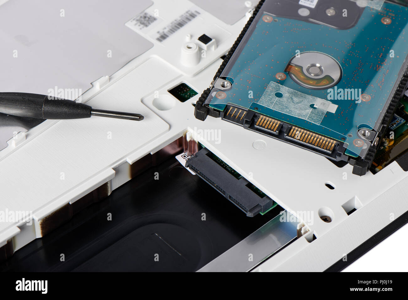 2.5inch hard disk drive with aseembly bracket and SATA slot on the access panel of laptop computer for hardware upgrade. Stock Photo