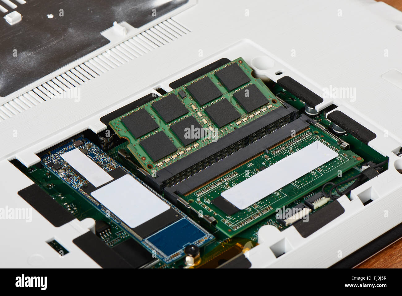 Access panel with DDR3L RAM and M.2 sata SSD on the bottom of a laptop, which has  RAM and SSD sata M.2 slot for hardware upgrade Stock Photo