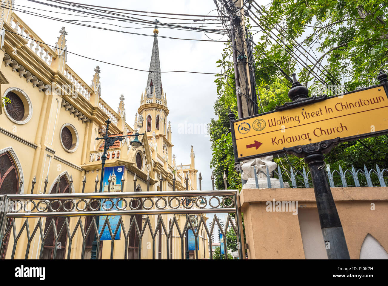 Holy Rosary Church (Kalawar Church) in Bangkok, Thailand, view from the street with a fence, wires & sign: Walking Street in Chinatown. Kalawar Church Stock Photo