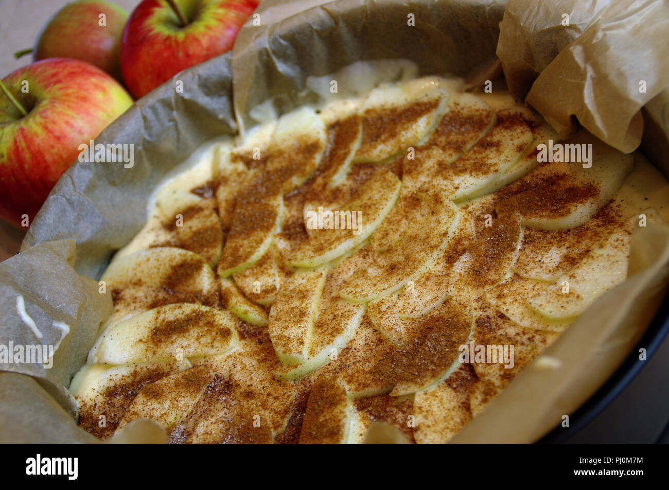 Raw apple cake ready for baking. Yeast pastry with cinnamon prepared