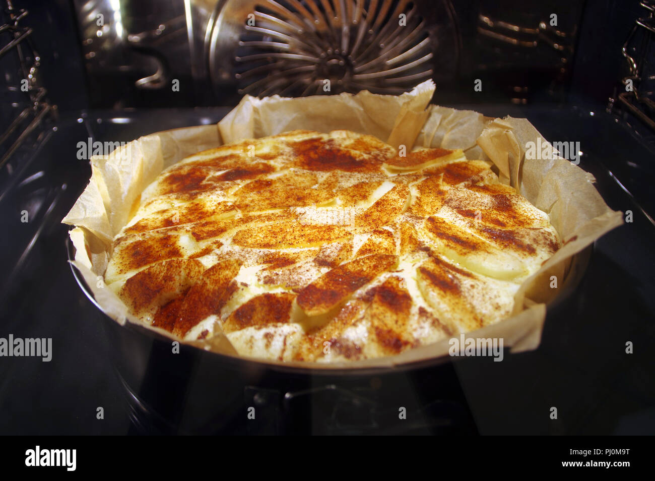 Cake cooking in oven. Baking yeast apple pie with cinnamon Stock Photo
