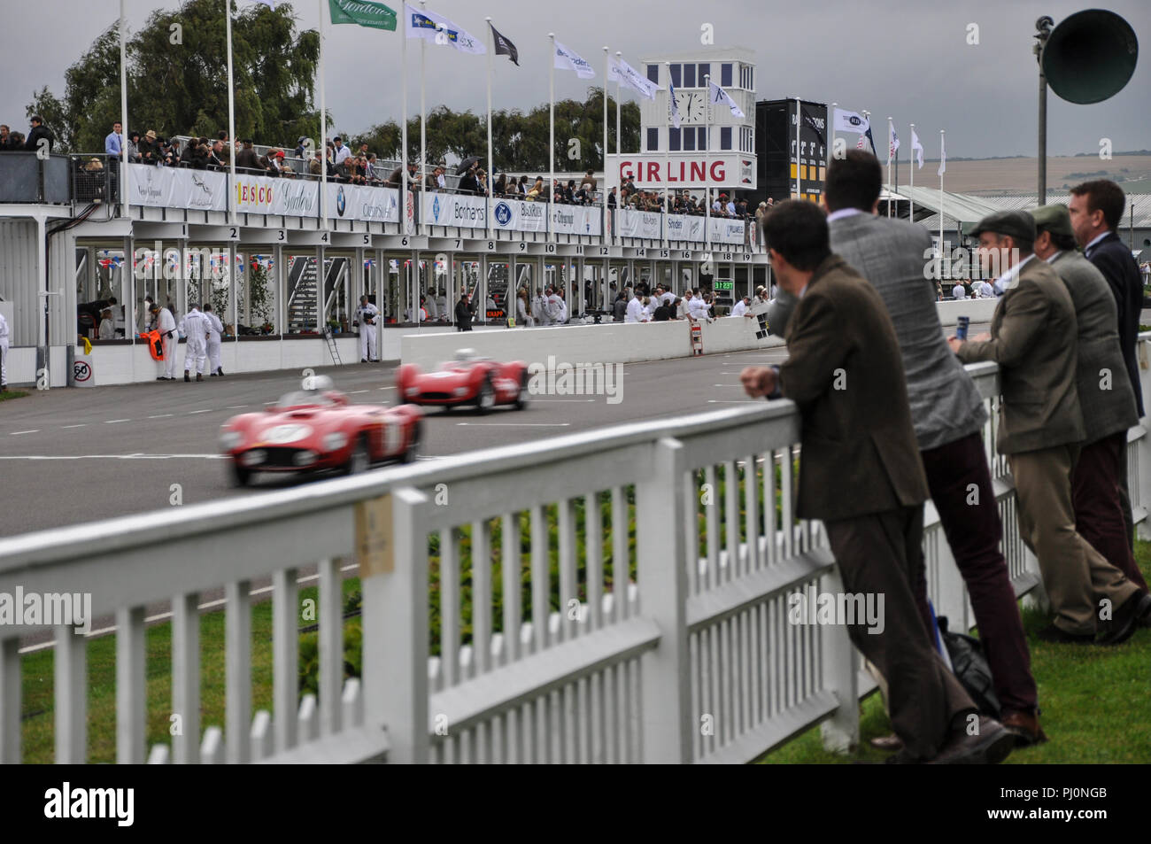 The Goodwood Revival The Freddie March Memorial Trophy race, endurance evening race, with people in period costume watching. Racing cars Stock Photo