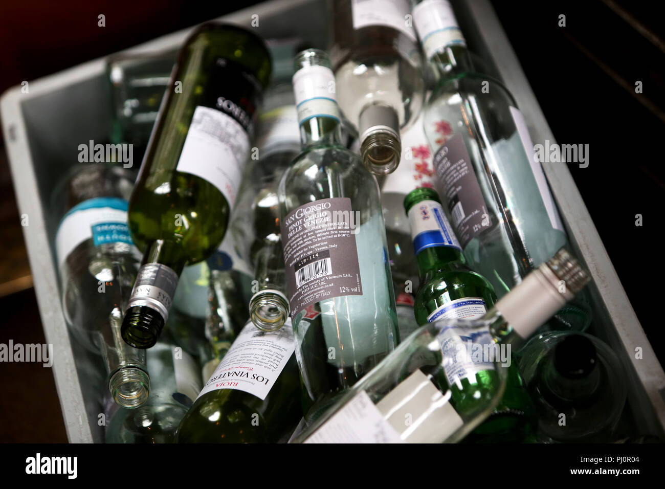 Selection of empty glass wine and beer bottles in a bin in London, UK. Stock Photo