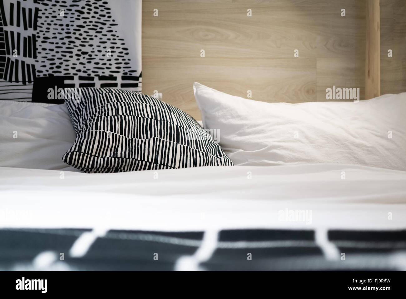 Black and white pillows and cushions on the bed in cozy bedroom Stock ...