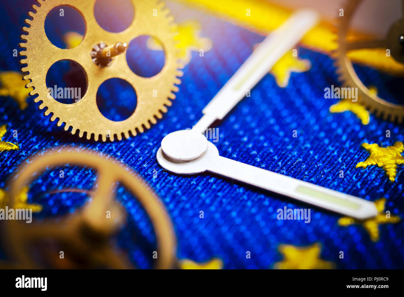 Watch hands and gear wheels on EU flag, end of changing clocks in the EU Stock Photo
