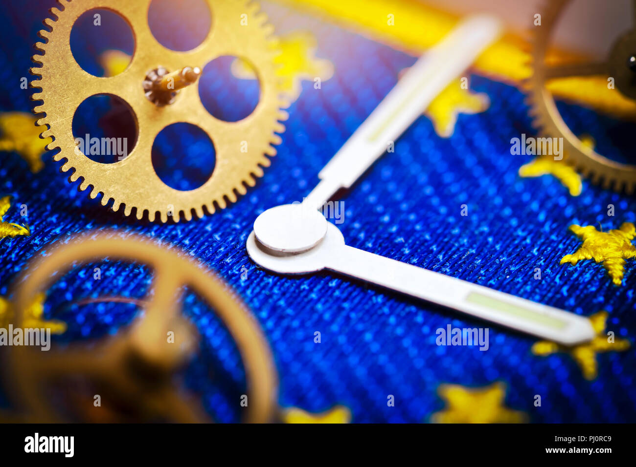Watch hands and gear wheels on EU flag, end of changing clocks in the