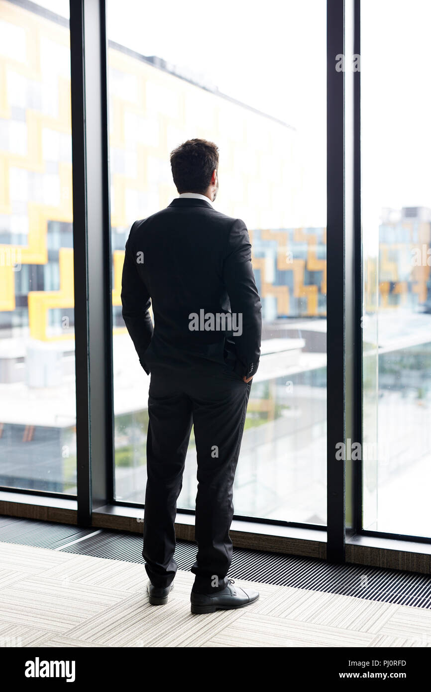 Pensive Businessman by Window Stock Photo