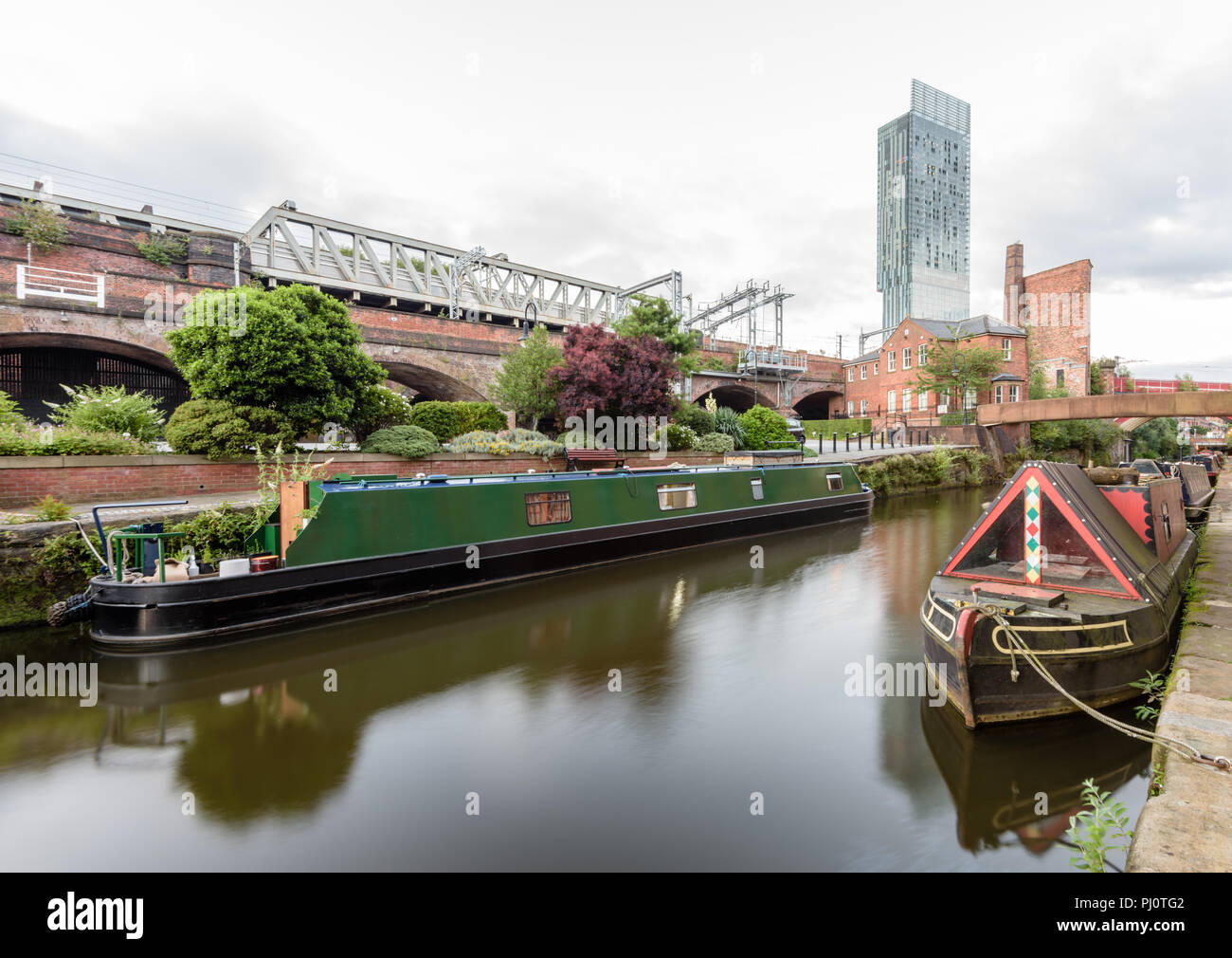 View along the Rochdale Canal from the Castlefield Basin in Manchester and looking towards the Hilton Hotel (Beetham Tower) and the railway bridge Stock Photo