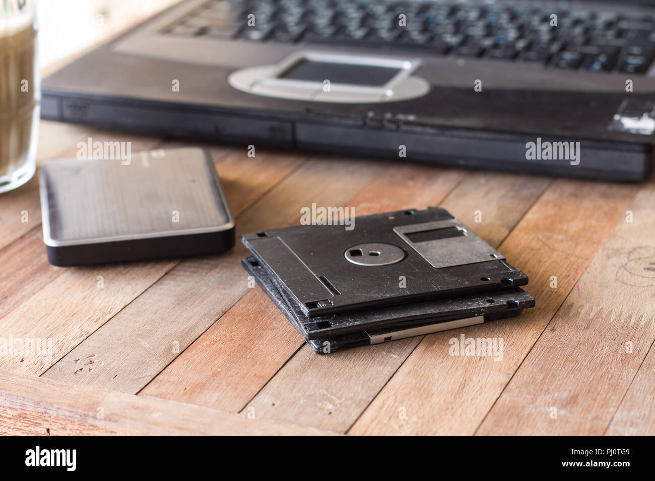 diskette on blur coffee in cup and blur notebook background, Stock Photo