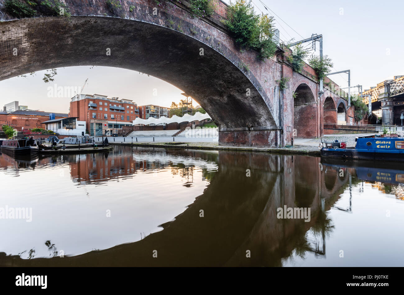 View from the towpath beside the Bridgewater Canal through the Castlefield Viaduct bridge and towards the Castlefield Bowl in Manchester Stock Photo