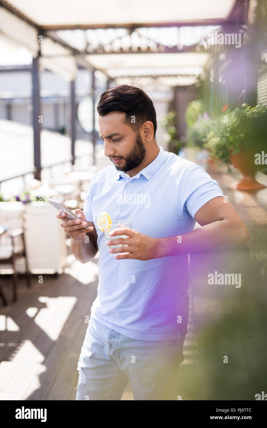 Handsome Middle-Eastern Man Using Smartphone Stock Photo