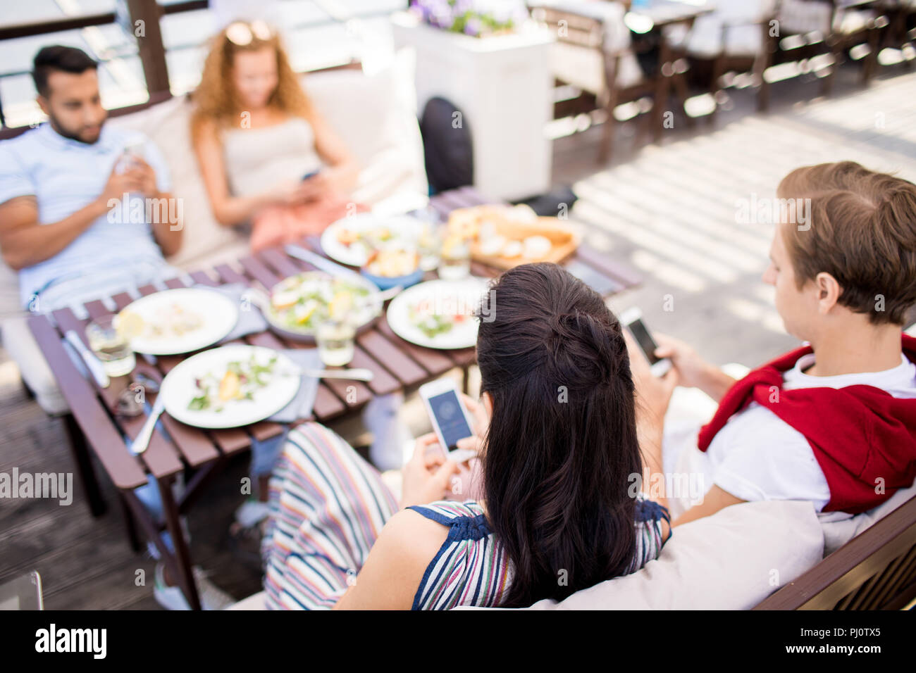 People Using Smartphones at Cafe Table Stock Photo