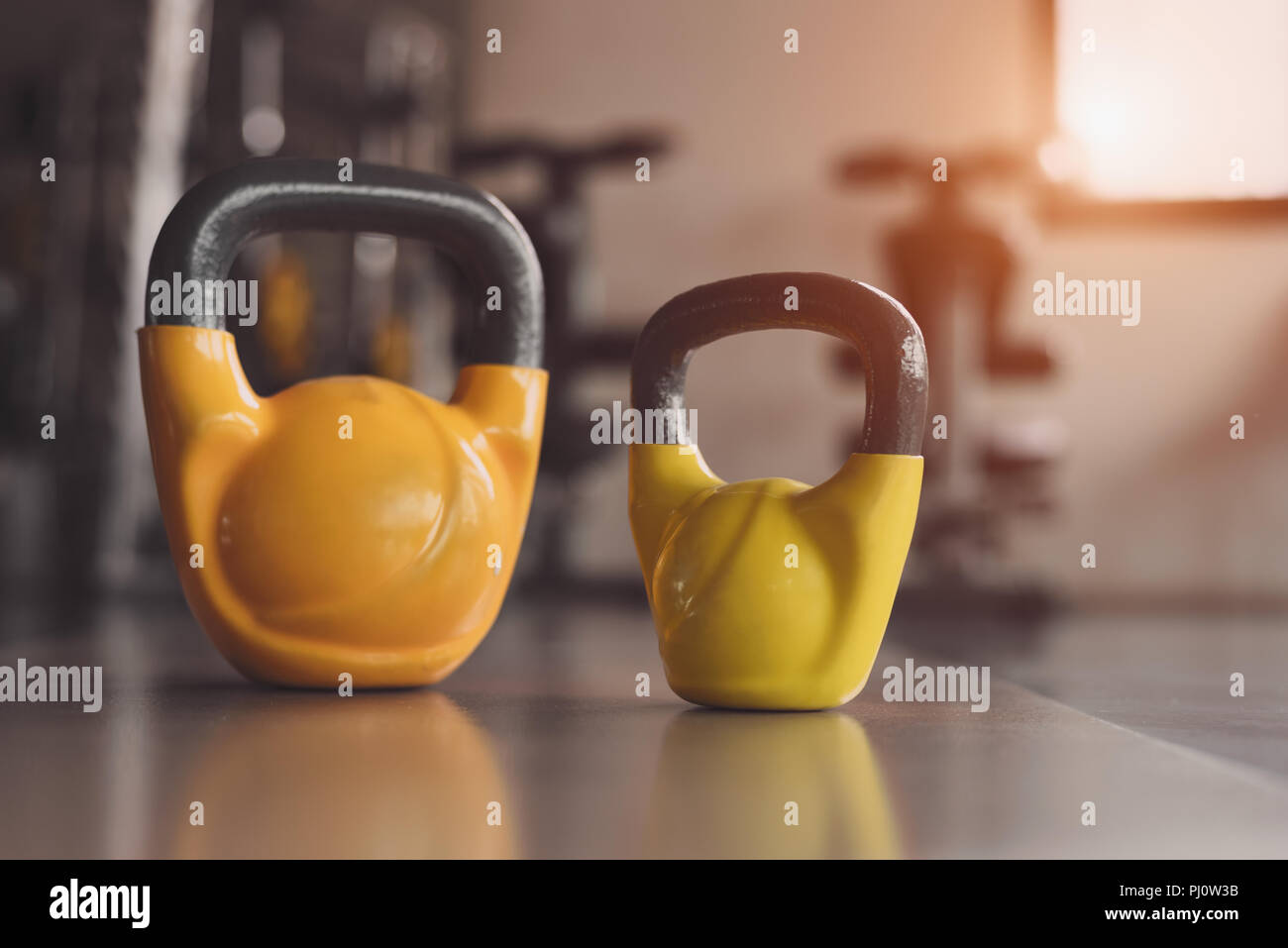 Two colorful kettlebells on fitness gym floor. Heavy weight sports