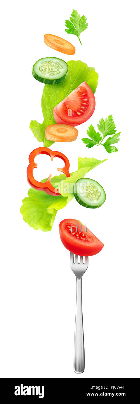 Isolated salad vegetables. Pieces of fresh tomato, cucumber, carrot, bell pepper and lettuce leaves in the air over a fork isolated on white backgroun Stock Photo