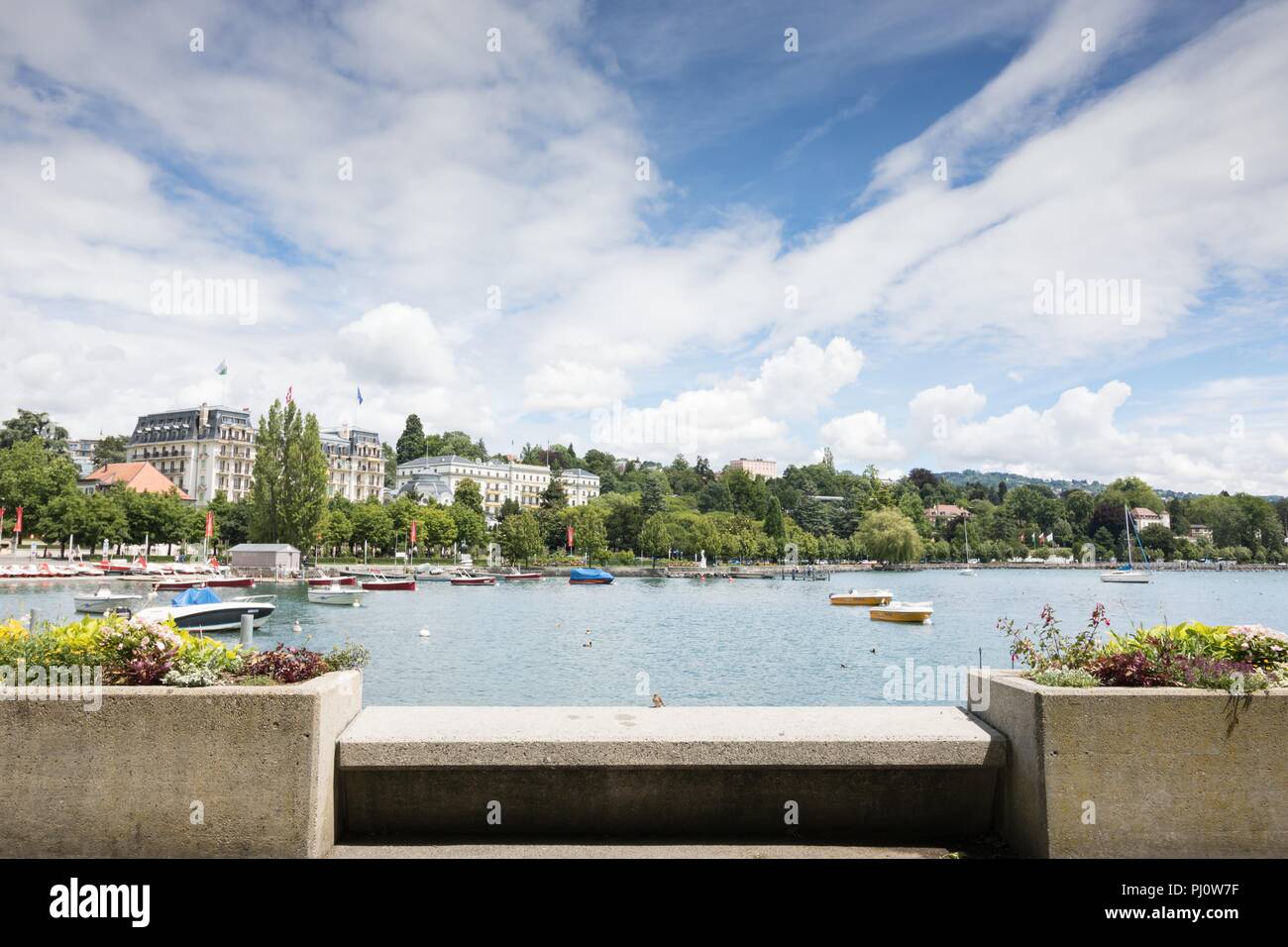 Peaceful view of Lake Geneva with some boats and buildings, Lausanne, Switzerland Stock Photo