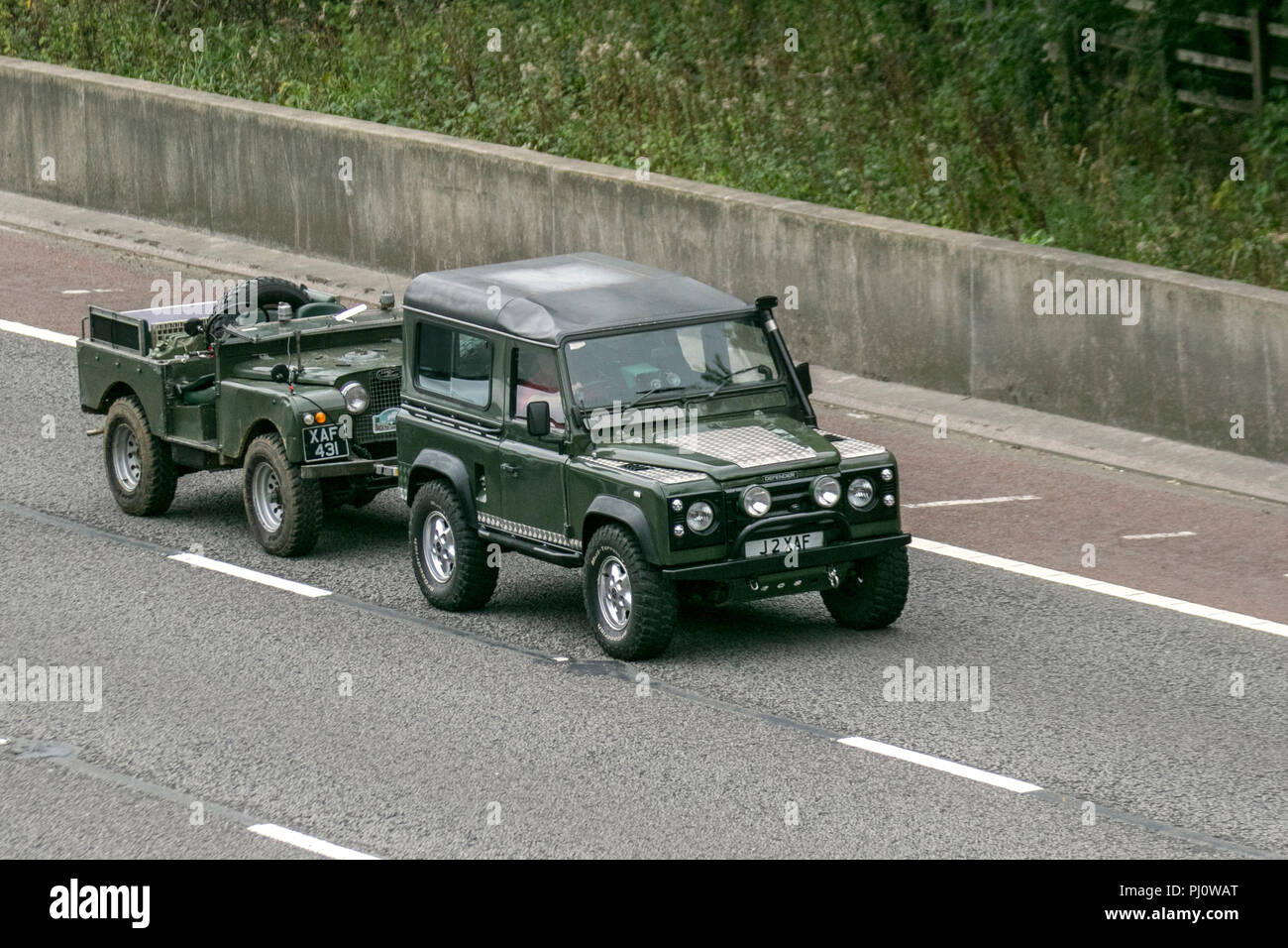 1993 90s 90 Land rover Defender turbo diesel with snorkel exhaust, Towing another Land Rover landrover suv 4x4, traffic on tow, the M6 at Lancaster, UK Stock Photo