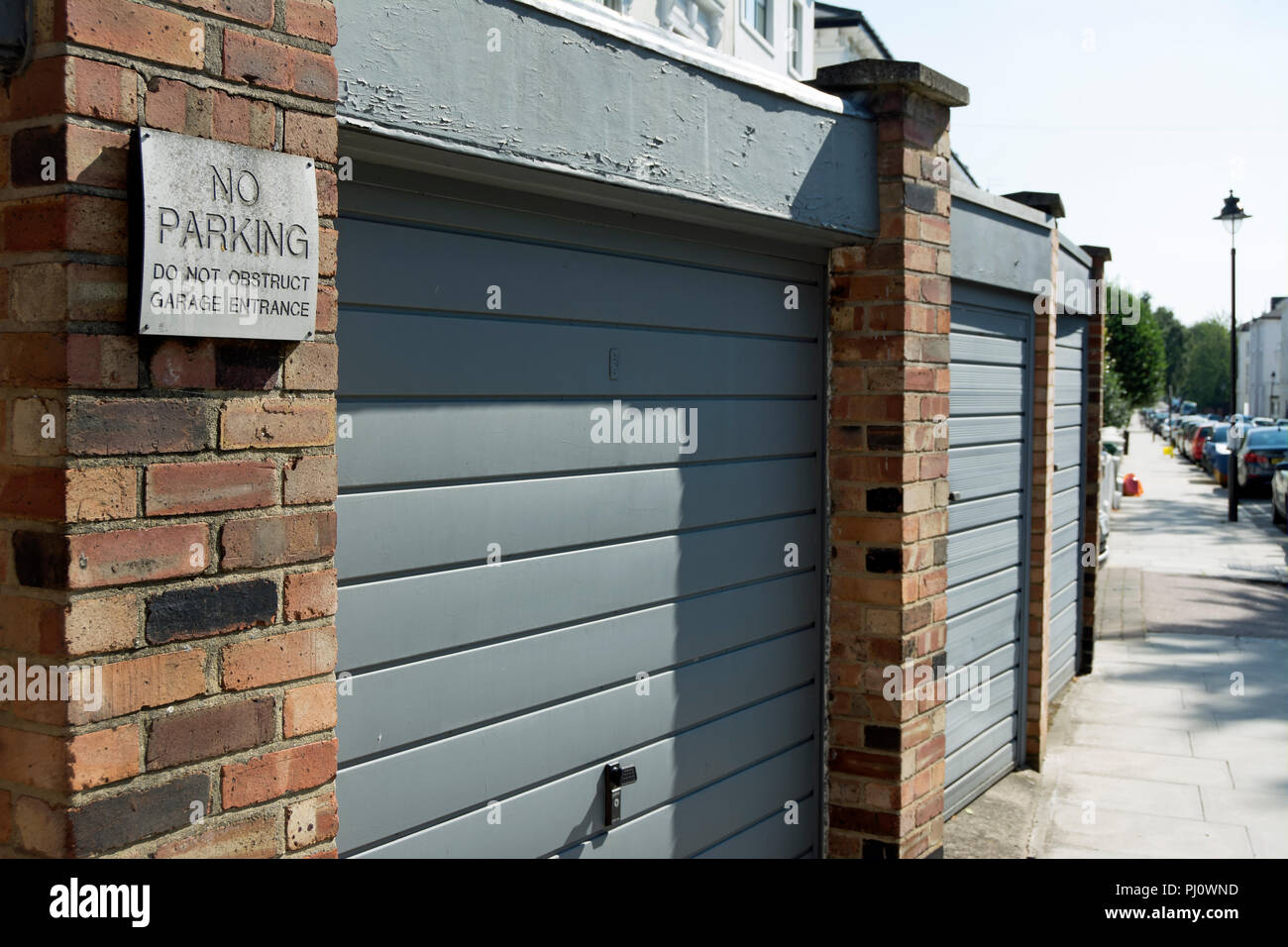 no parking do not obstruct garages sign by a row of garage doors in belsize park, london, england Stock Photo