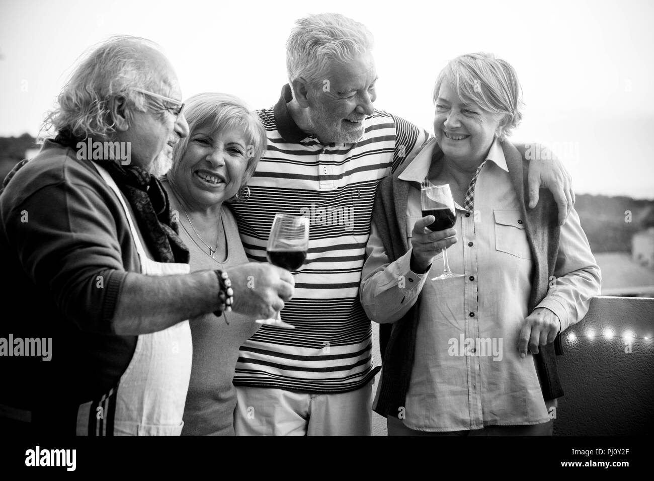 celebration event outdoor for a group of adult people. drkinking wine in the rooftop terrace with nice view on the background. happy lifestyle togethe Stock Photo