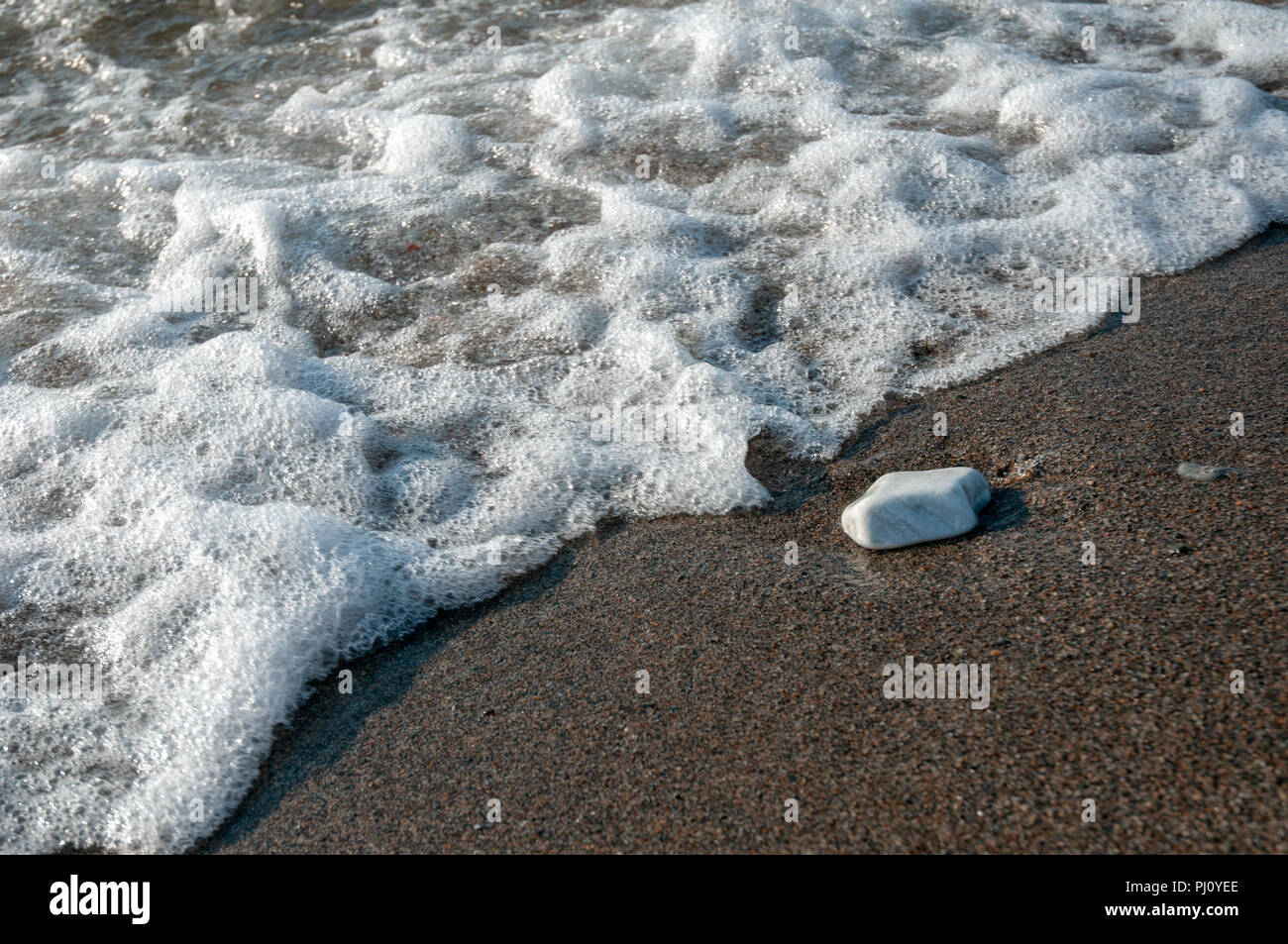 A group of pebbles by the sea shore interacting with the tide Stock ...