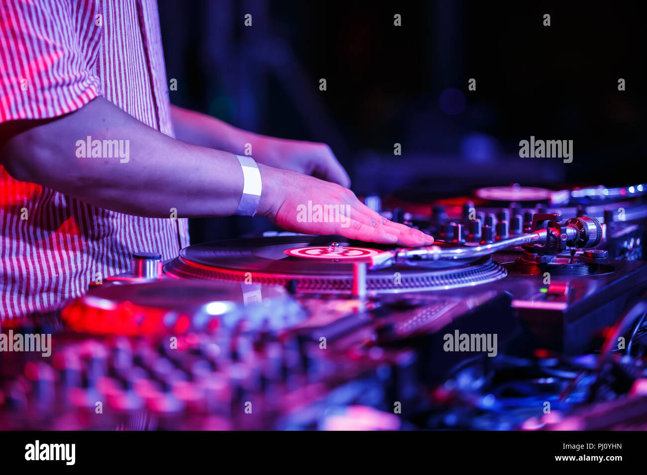 Hip hop concert dj scratches vinyl records on turntables at entertainment event in
