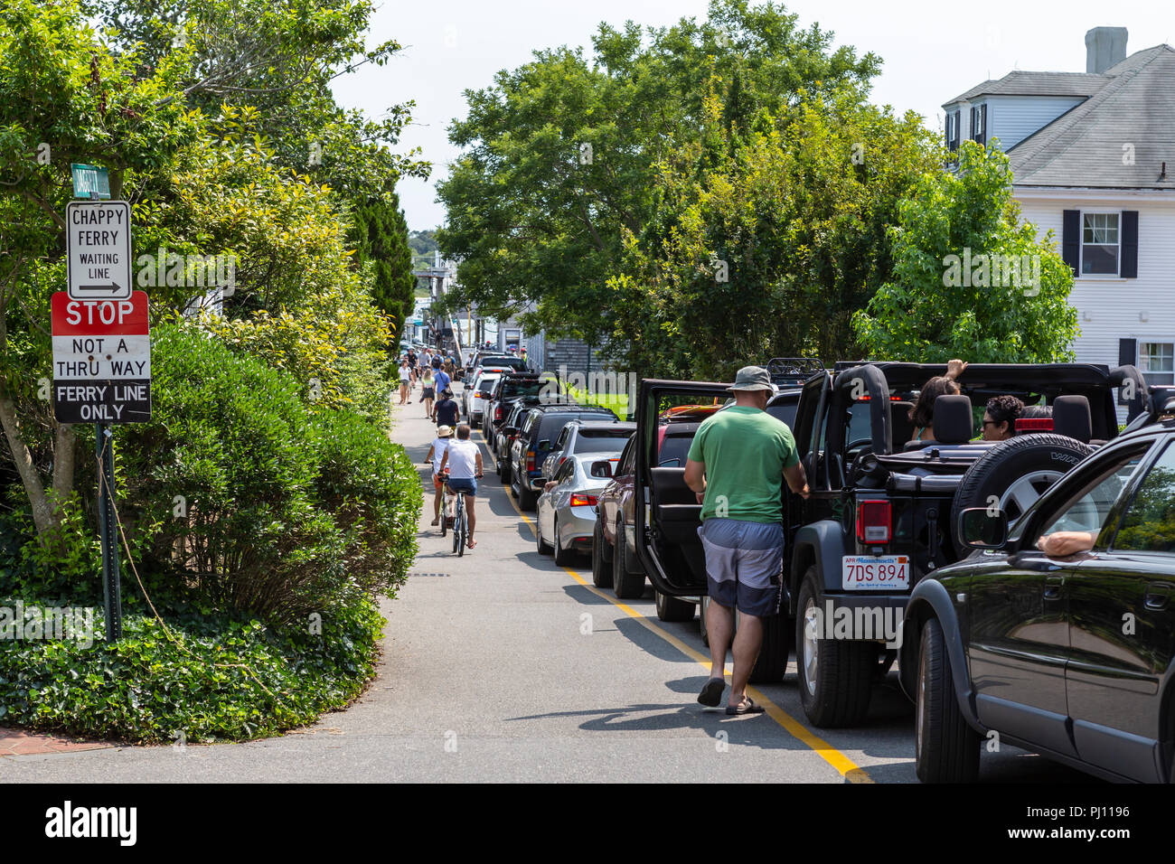 A long line of cars waits on local streets to take the Chappy Ferry to Chappaquiddick Island in Edgartown, Massachusetts on Martha's Vineyard. Stock Photo