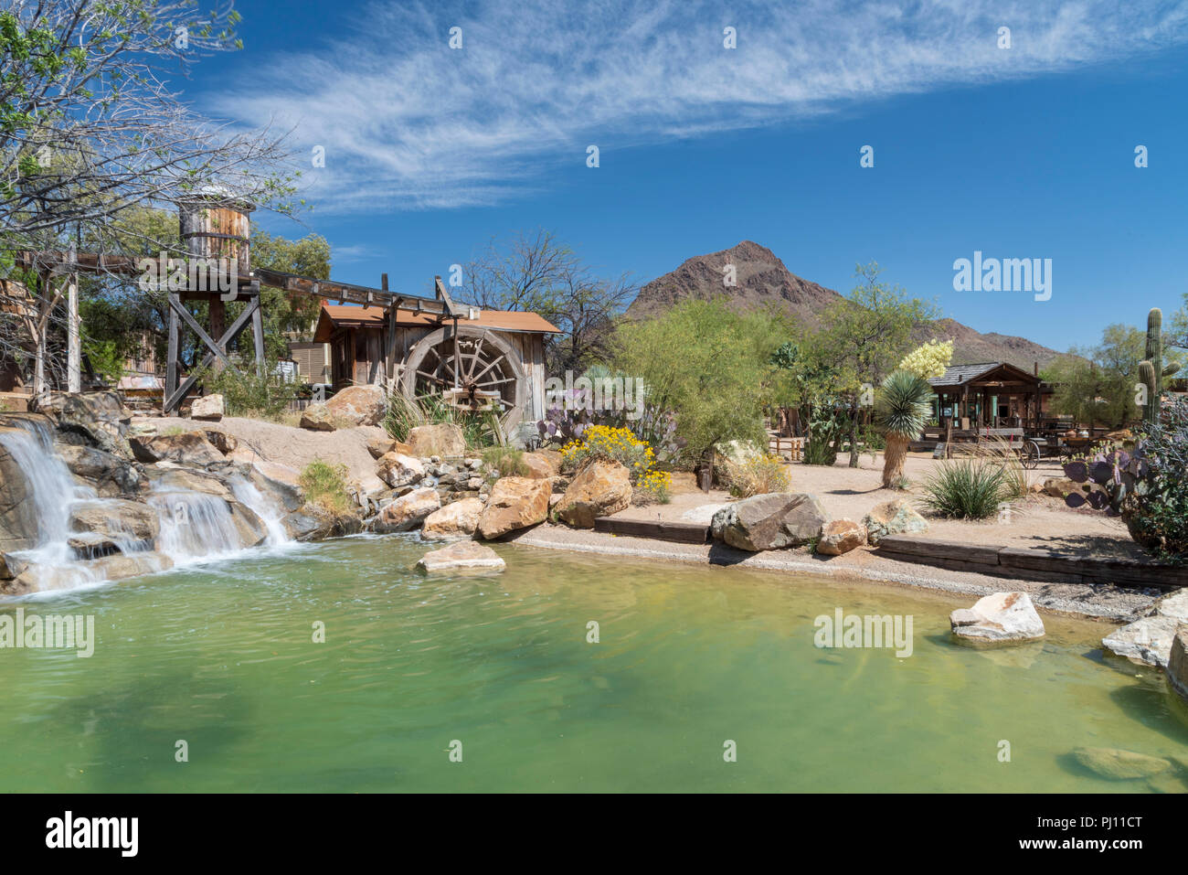 Cement pond with waterfall, water tower and water wheel at Old Tucson