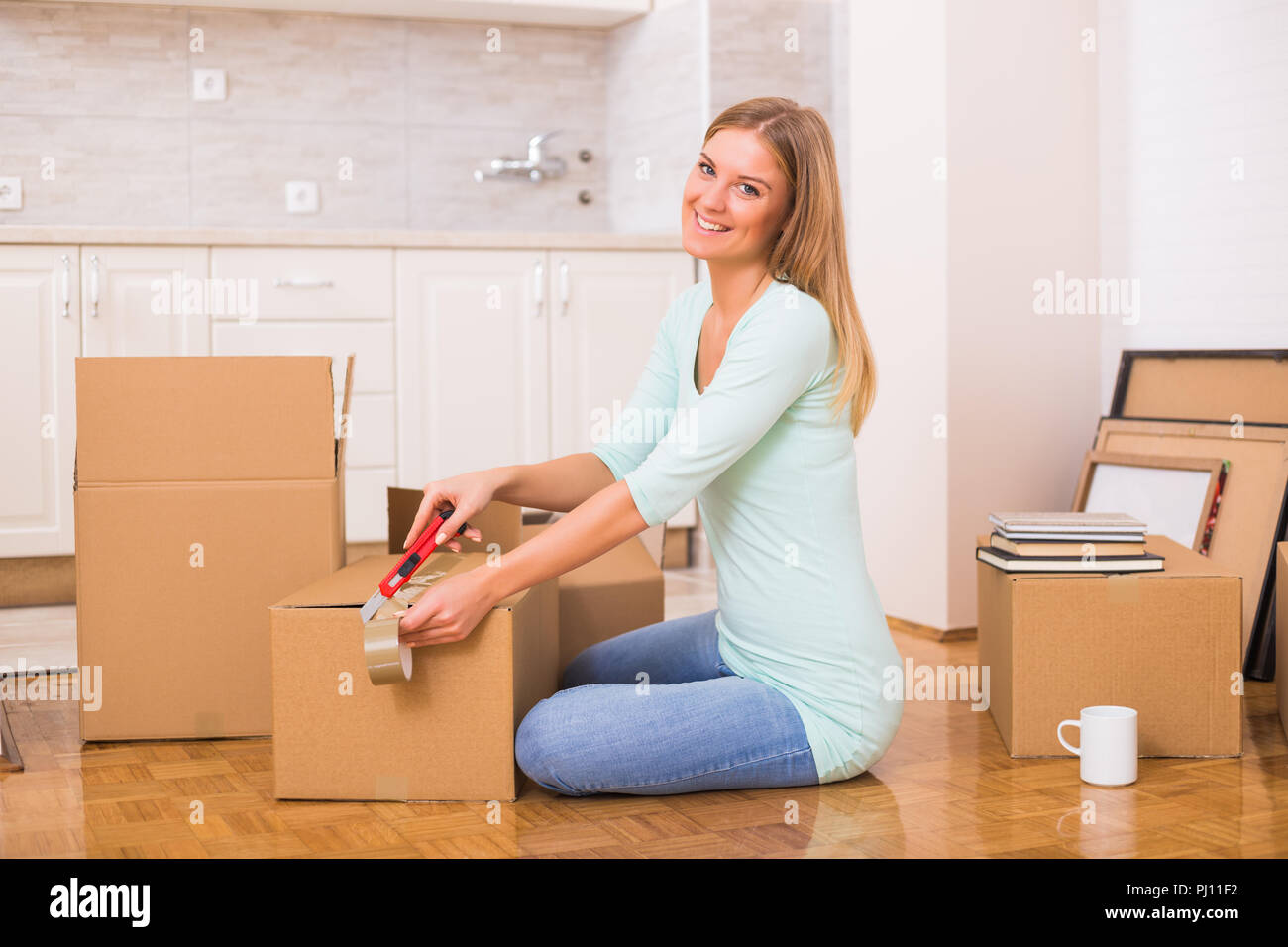 Beautiful woman moving into new home. Stock Photo