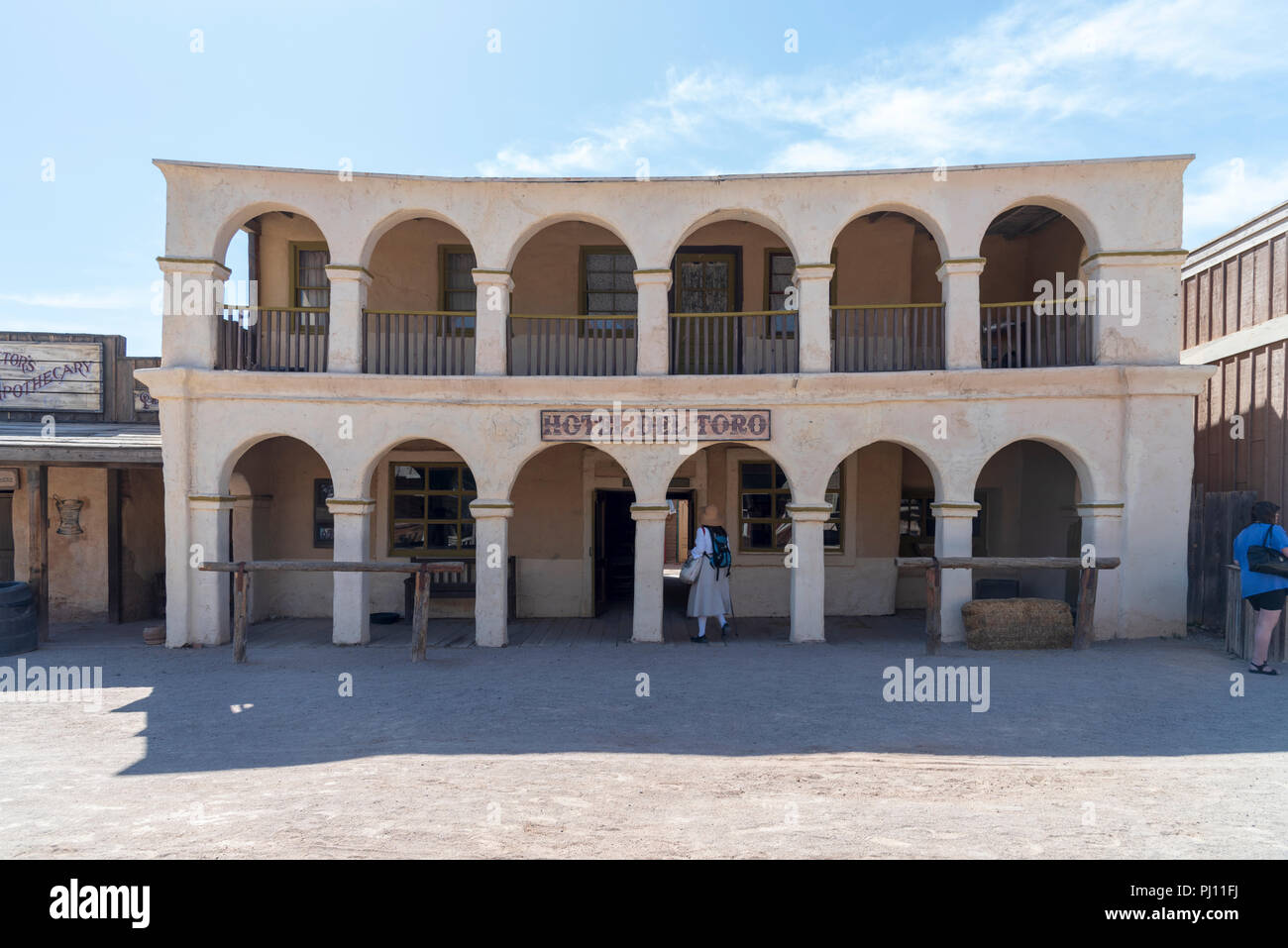 Old west hotel with archways on both first and second story. Dirt street with tourists, Old Tucson movie studios. Stock Photo