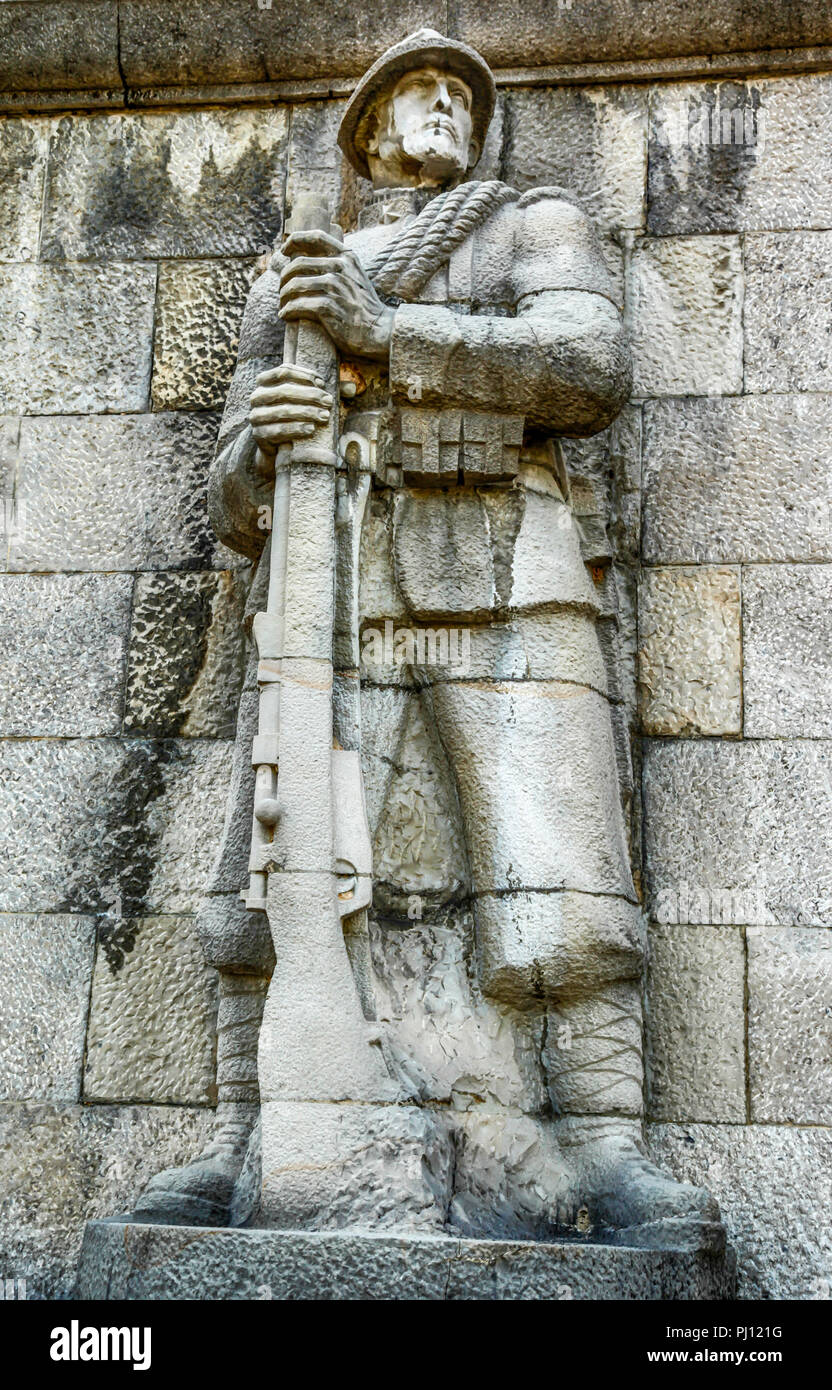 Italian Fascist Alpine soldier statue on the wall outside the Catholic Church, Parrocchia di S, Nicolo Vescovo al Tempio Ossario in the Piazzale XXVi  Stock Photo