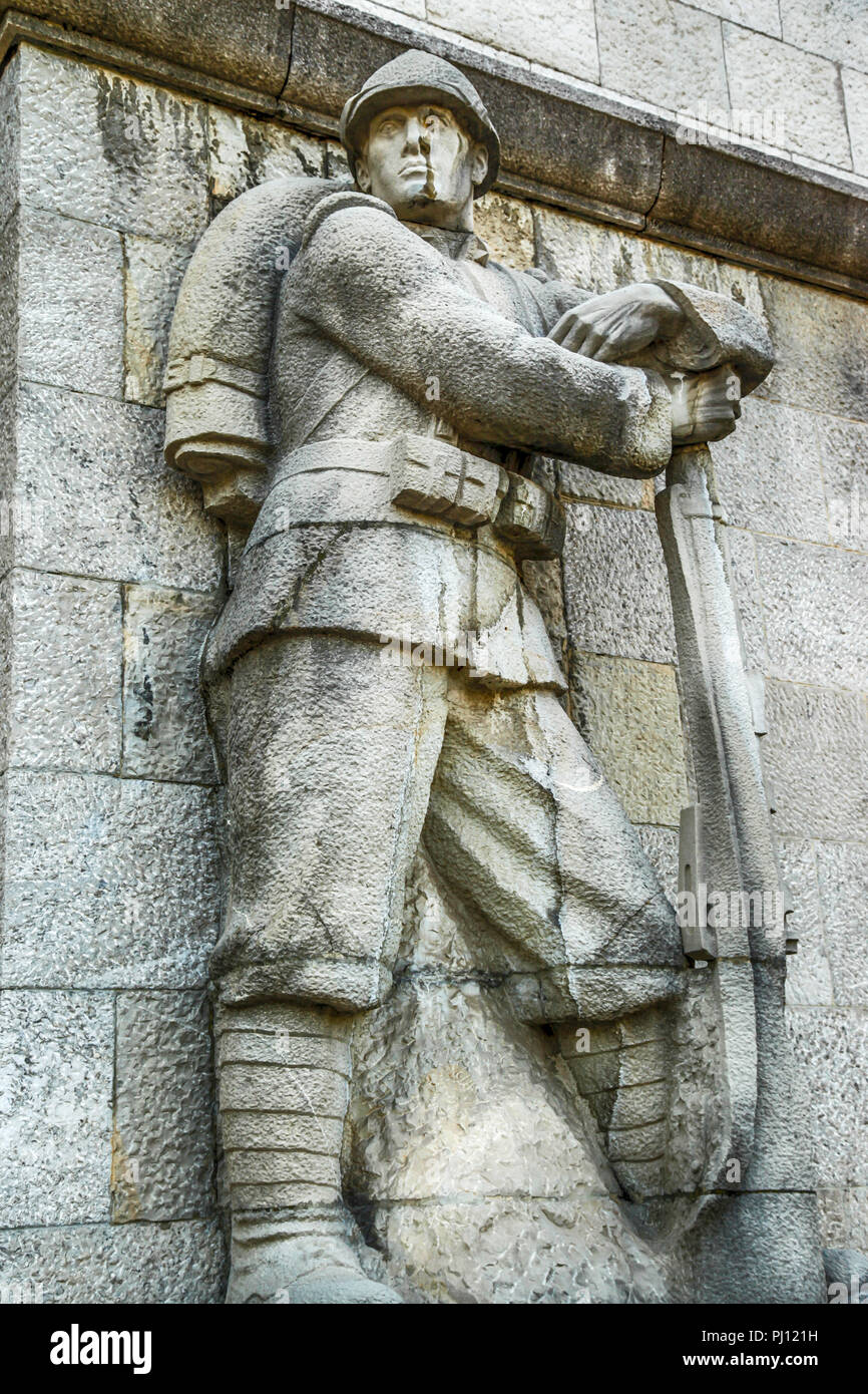 Italian Fascist Alpine soldier statue on the wall outside the Catholic Church, Parrocchia di S, Nicolo Vescovo al Tempio Ossario in the Piazzale XXVi  Stock Photo