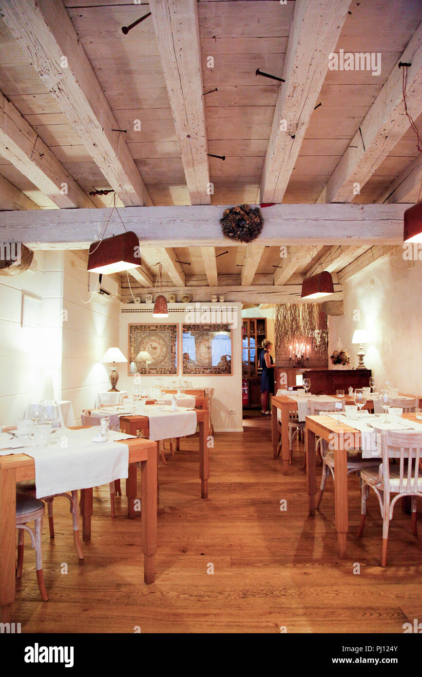 rustic French farmhouse style interior of the Trattoria Antica Maddalena restaurant on Via Pelliccerie in Udine, Italy Stock Photo