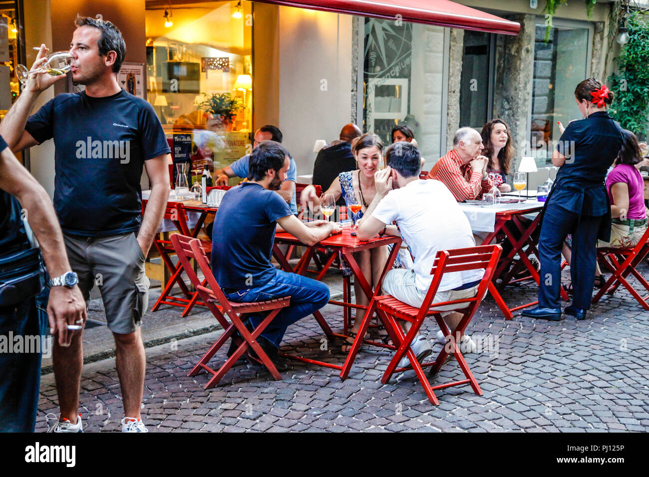 People enjoying a drink and a meal outside the Trattoria Antica Maddalena  on Via Pelliccerie in Udine, Italy Stock Photo - Alamy, image size:1300x956