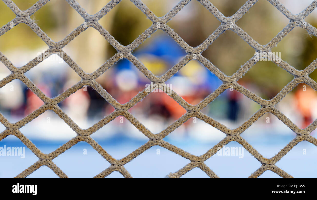 Closeup of a hockey net against a colorful out of focus background. Stock Photo