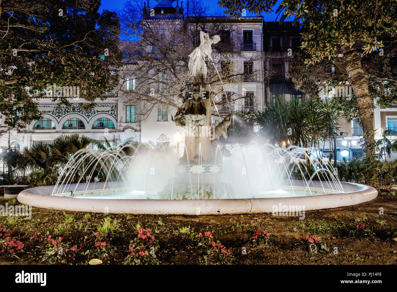 Fountain at Plaza Gabriel Miro square. Sculpture, statue of girl and splashing water illuminated at night. Alicante city, Costa Blanca. Spain Stock Photo