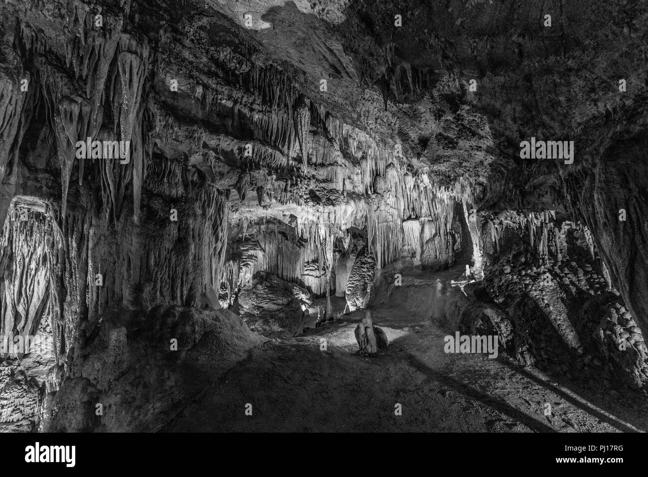 Deep inside a cavern filled with stalagmites and stalctites and eerie lighting. Stock Photo