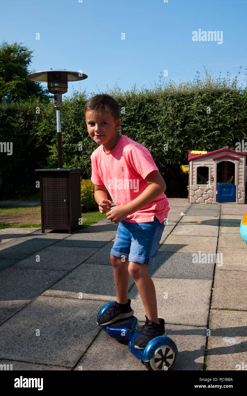 Young 7 year old boy riding a Hover Board in his back garden, England, UK. Stock Photo