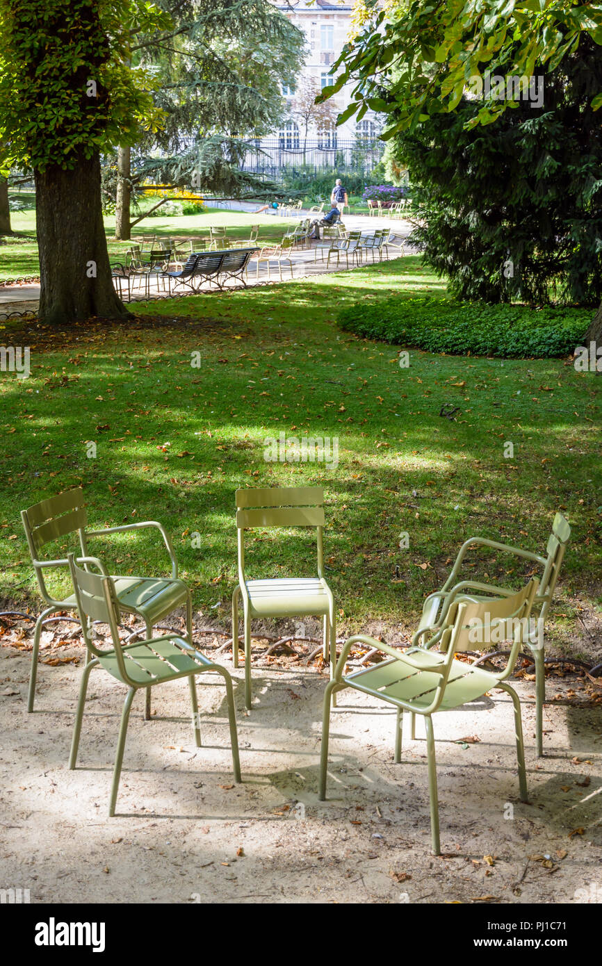 Green typical metal lawn chairs gathered in circle in an alley of