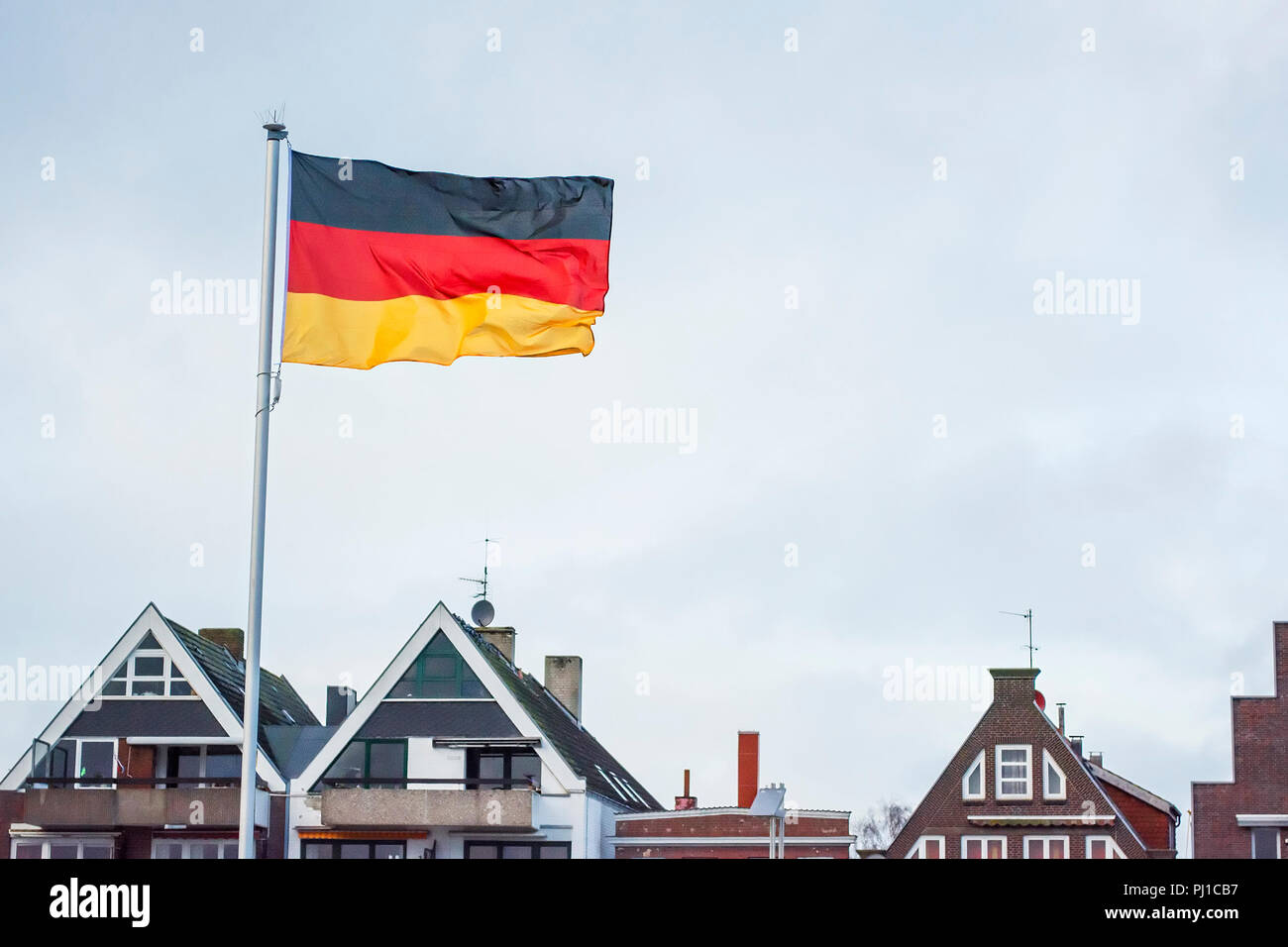 German flag and rooftops, Travemunde, Lubeck, Germany Stock Photo