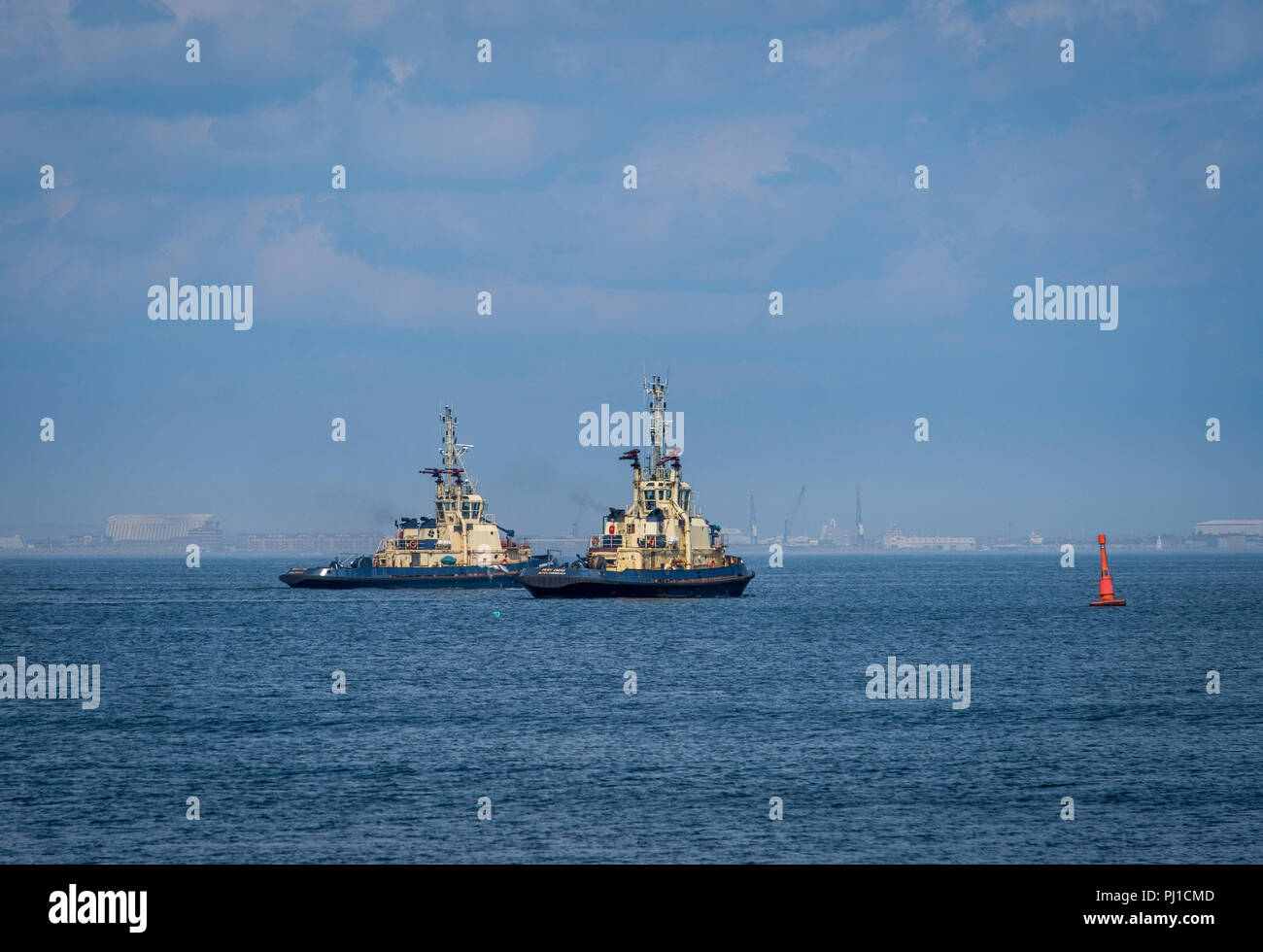 Tugs set out of the Tees to bring in a ship. Stock Photo