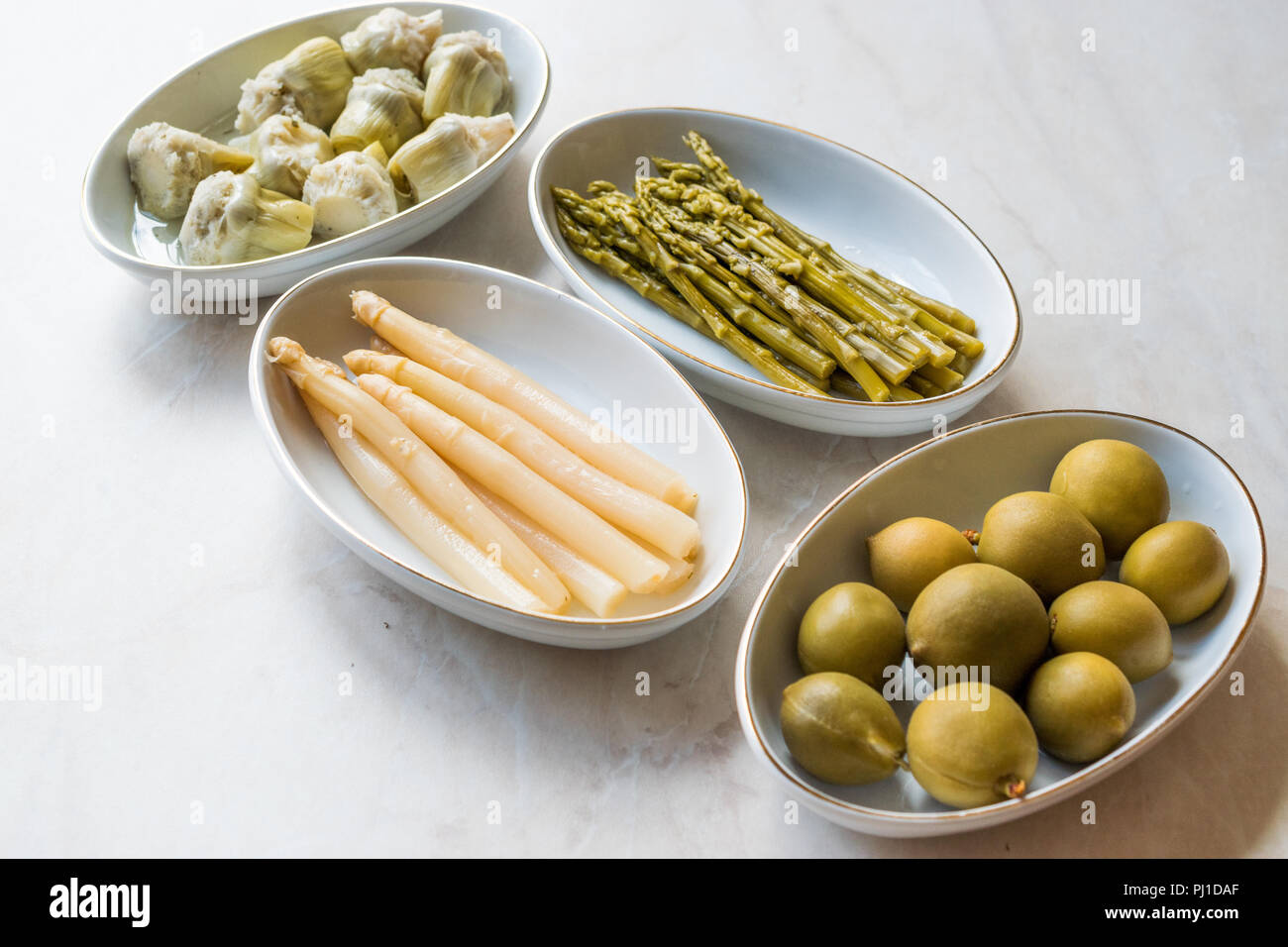 Pickled Vegetables Green and White Asparagus, Artichoke Heart and Unripe Green Almond Pickles in Plate. Organic Food. Stock Photo