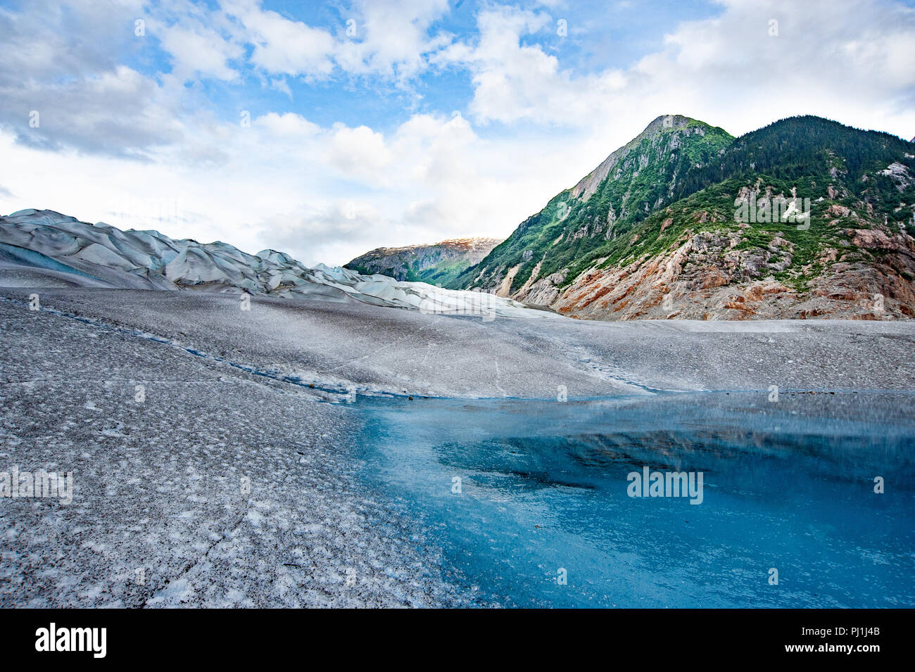 Glacier helicopter tour - Juneau Alaska - cruise ship excursion over the Juneau icefield landing on Gilkey Glacier - stunning blue glacial meltwater Stock Photo
