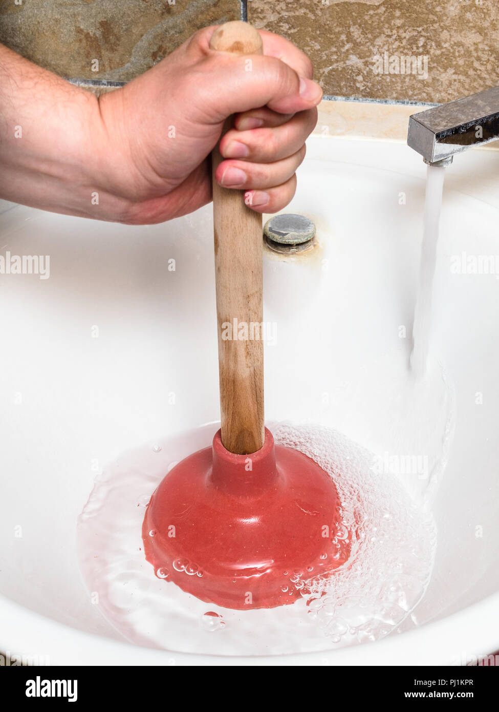 Plumber Clears Water Blockage In Sink Drain By Plunger Stock