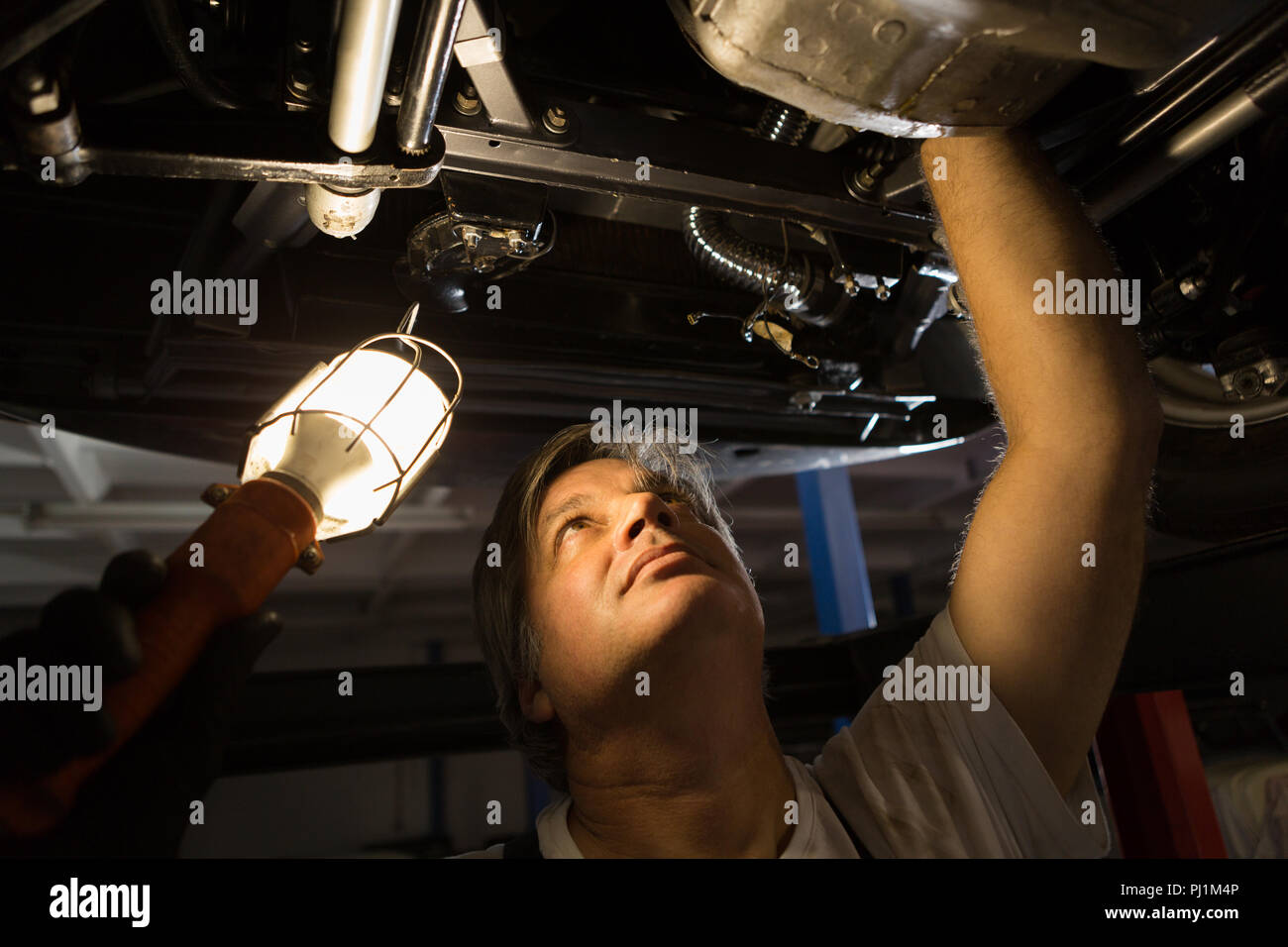 Male mechanic examining a car Stock Photo Alamy