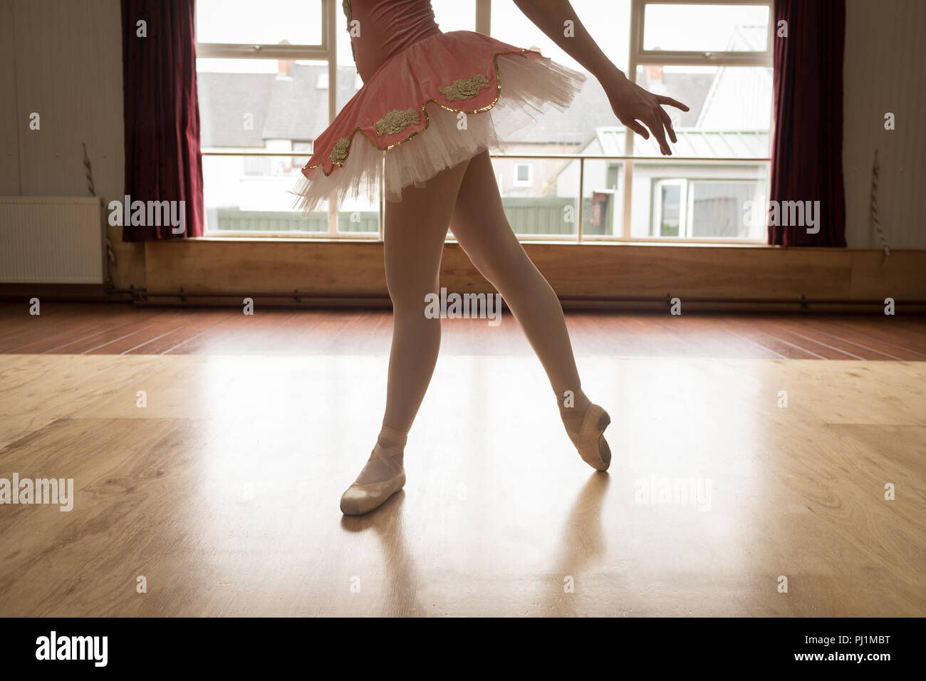 Ballerina Dancing On Wooden Floor In Dance Studio Stock