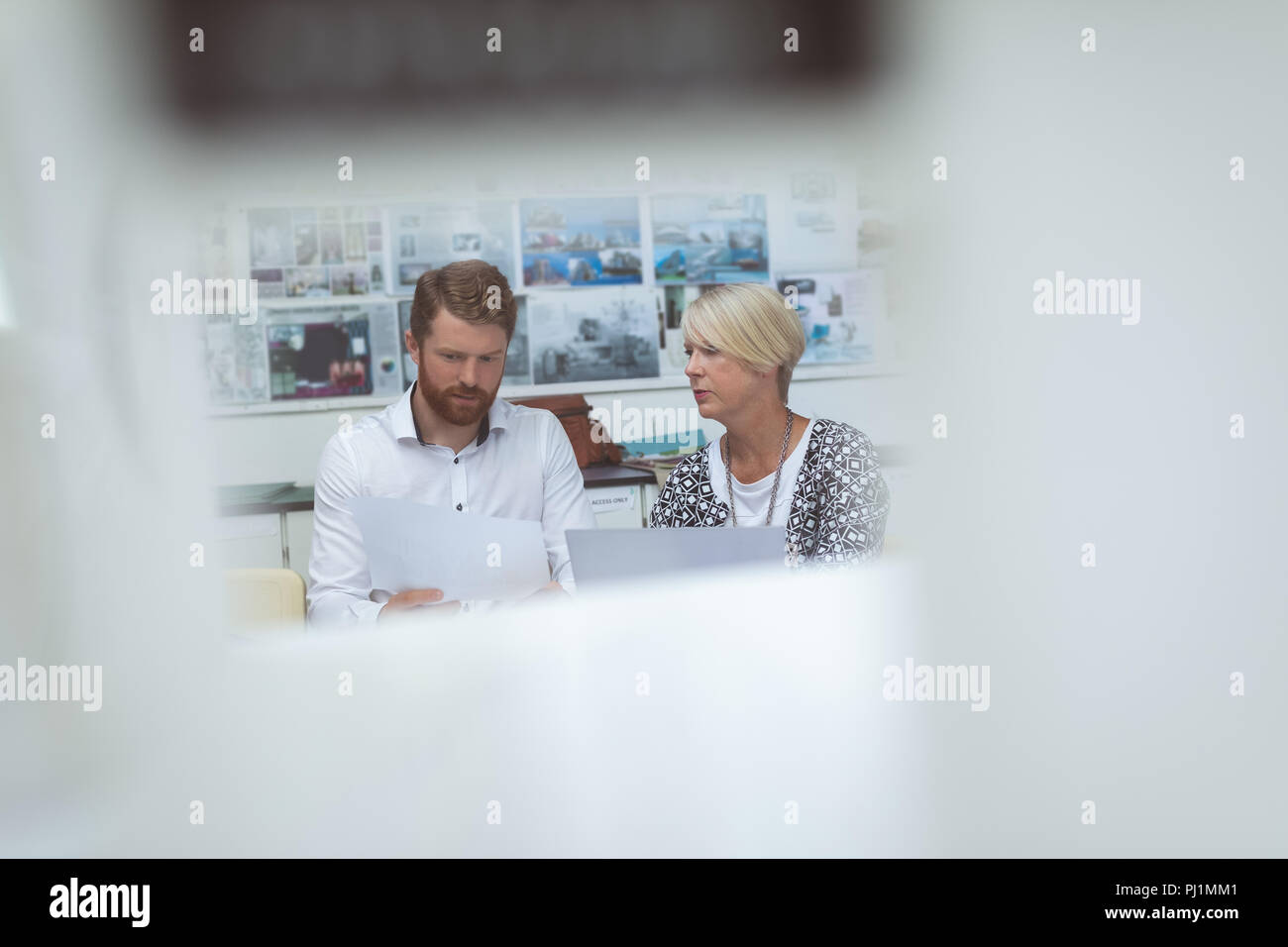 Executives discussing over document at desk Stock Photo