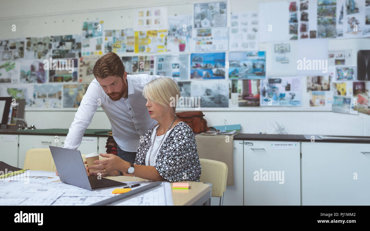 Executives discussing over tablet at desk Stock Photo