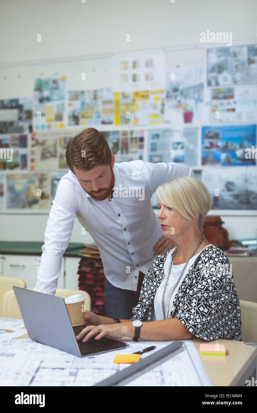 Executives discussing over tablet at desk Stock Photo