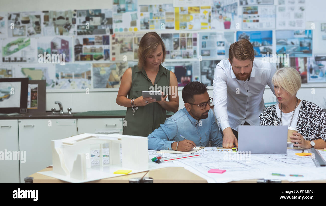 Executives discussing over tablet at desk Stock Photo